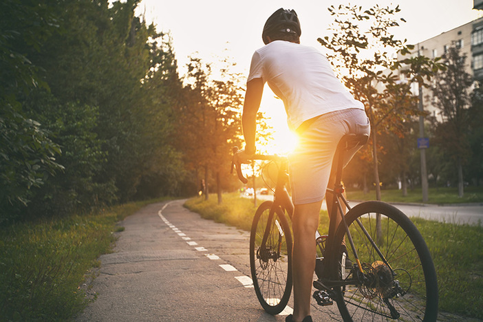 3 Simple Ways to Cut Back & Save Money Without Feeling Deprived The young guy in casual clothes is cycling on the road in the evening city