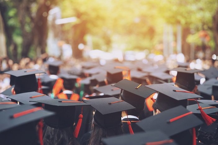 How to Start Saving for College With Real Estate (Hint: Ditch the 529) backside graduation hats during commencement ceremony