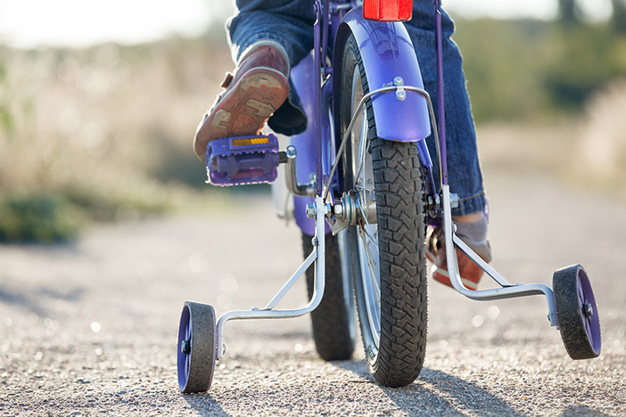 3 Telltale Signs You’re Definitely NOT Ready to Invest in Real Estate Kids bike with training wheels closeup