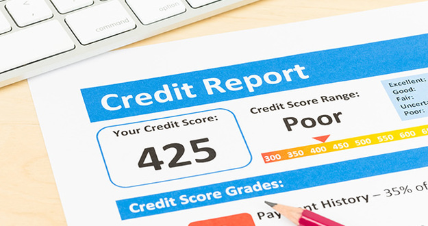 How to Build Credit From Scratch Poor credit score report with pen and keyboard