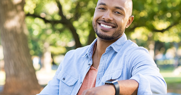 Work Less & Earn More With Commercial Investments—Here’s How Young african man relaxing at park in a summer day.