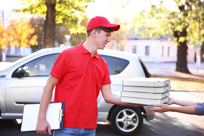 House Passes $15 Minimum Wage: What Does It Mean for Workers and the Economy? Pizza delivery boy holding boxes with pizza near car