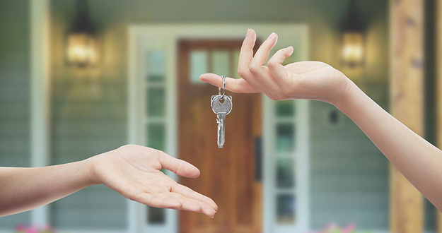 Buying Property? 7 Things to Look for When Doing a Final Walk-Through closeup of human hand with key dropping key into another person's open palm in front of a house