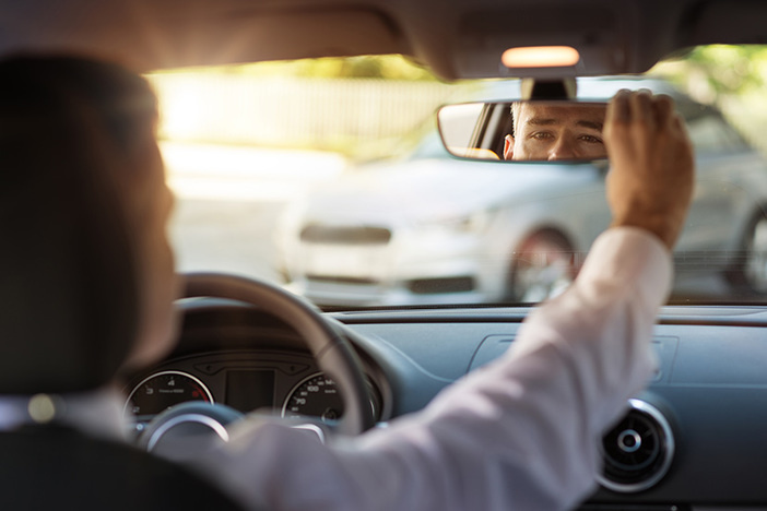 The Top 3 Things I Wish I’d Done Differently as a New Real Estate Investor Man sitting in a car and adjusting rearview mirror, car interior