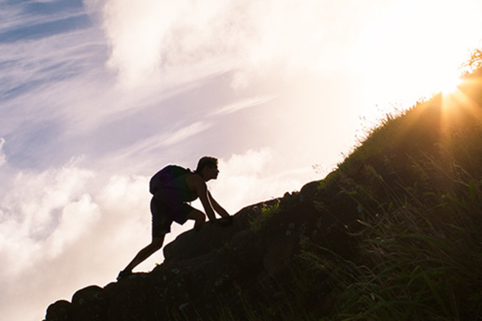 How to Build Massive Wealth During a Recession: Master These 5 Principles silhouette of man wearing backpack climbing uphill in sunshine