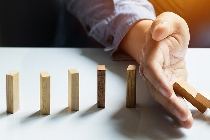 Key Takeaways From the ’08 Recession That Apply Today businessman hand stop dominoes continuous toppled, Panoramic composition suitable for banners