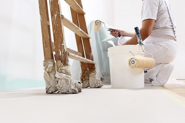 Remodeling During COVID? These Home Improvement Projects Offer the Best ROI painter at work with a roller, bucket and scale, from below view