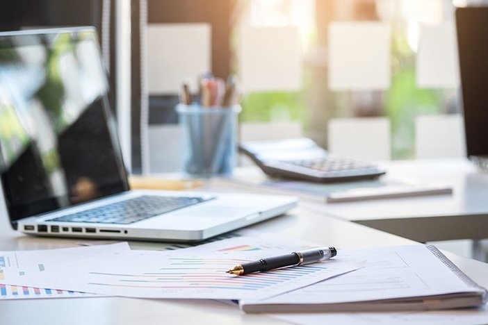 9 Tips To Survive a Real Estate Audit Business desk with a keyboard, report graph chart, pen and tablet on white table