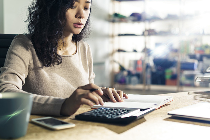 How to Determine a Property’s Value Using Real Estate Comps Portrait of a concentrated Asian accountant at her workplace using her calculator. Concept of accounting in business.