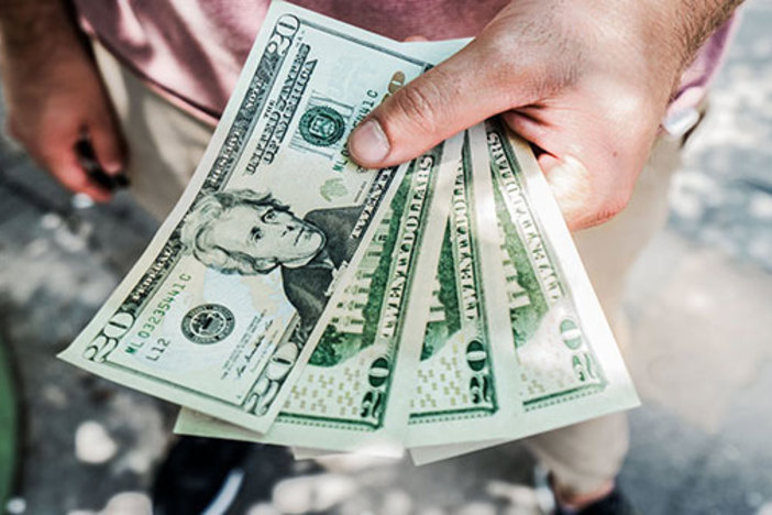 7 Sharing Economy Side Hustles Real Estate Investors Can Use to Earn Extra Cash closeup of hand holding fanned cash