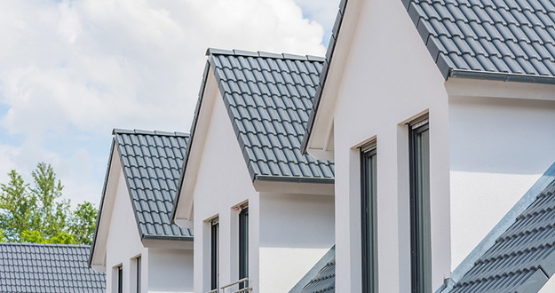 How I Bought a Fixer-Upper Fourplex for $1 Down: A BRRRR Case Study close up view of upper level windows and roofs on four row homes